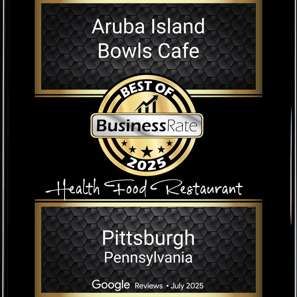 A black and gold award plaque for Aruba Island Bowls Cafe, Best Health Food Restaurant 2025.